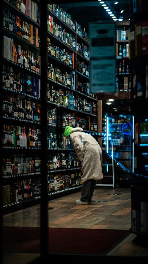 an older man picks up a ball in a store