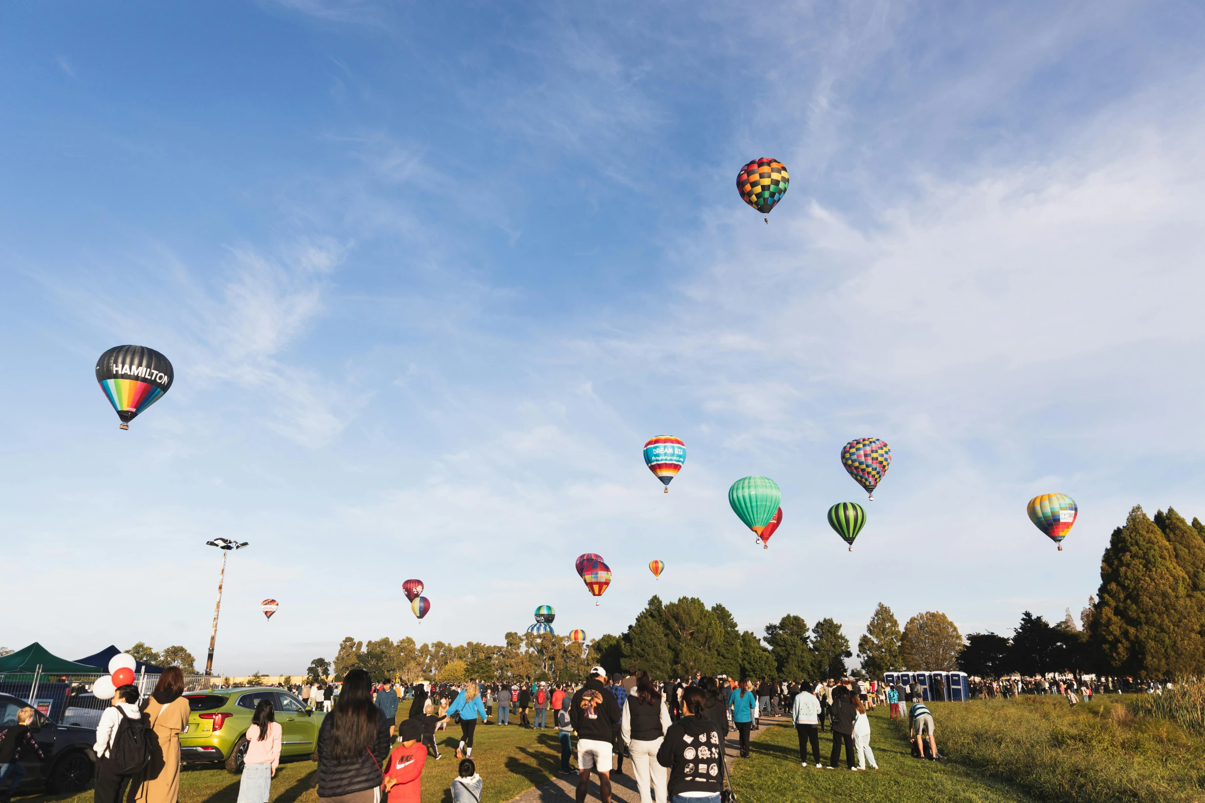 several  air balloons flying over a crowd