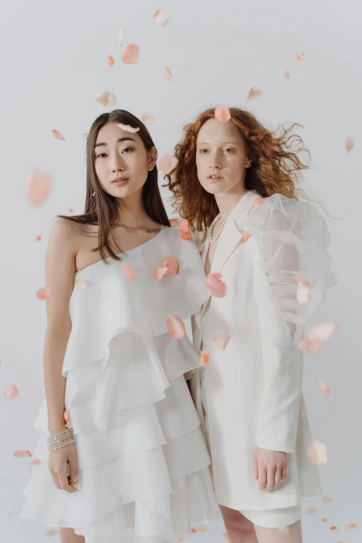 two young women standing in front of confetti in the air