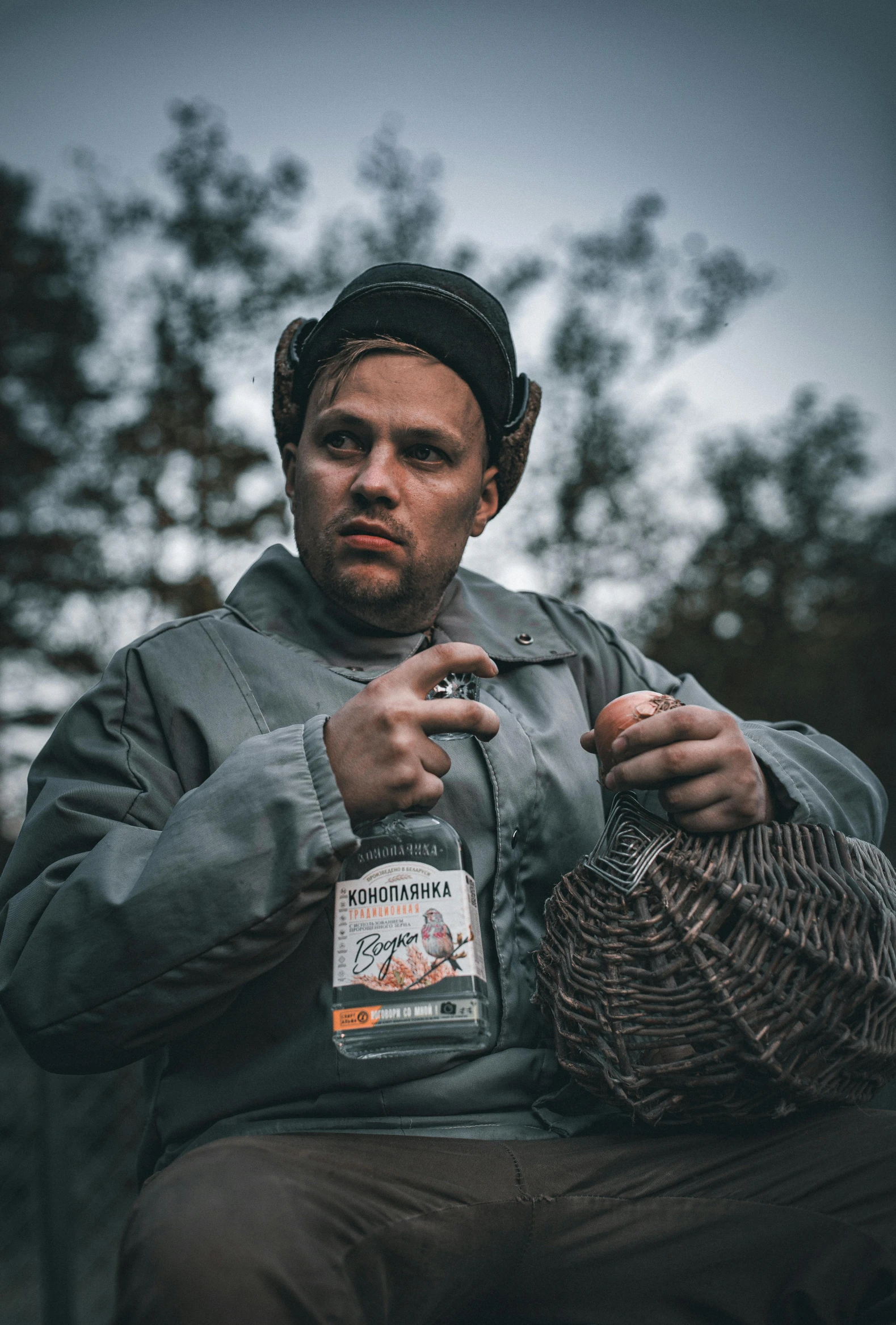 a man sitting down and smoking in a hat