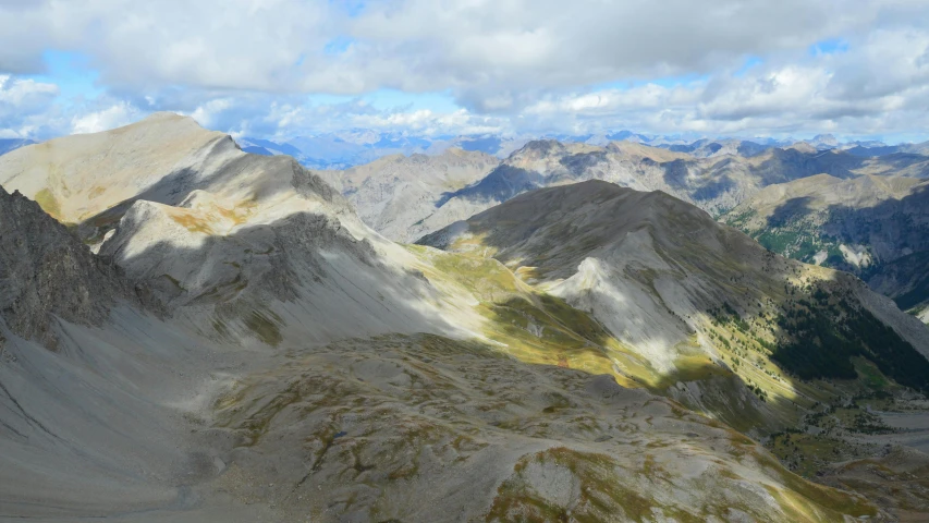 mountains covered in rocky area with green and yellow vegetation