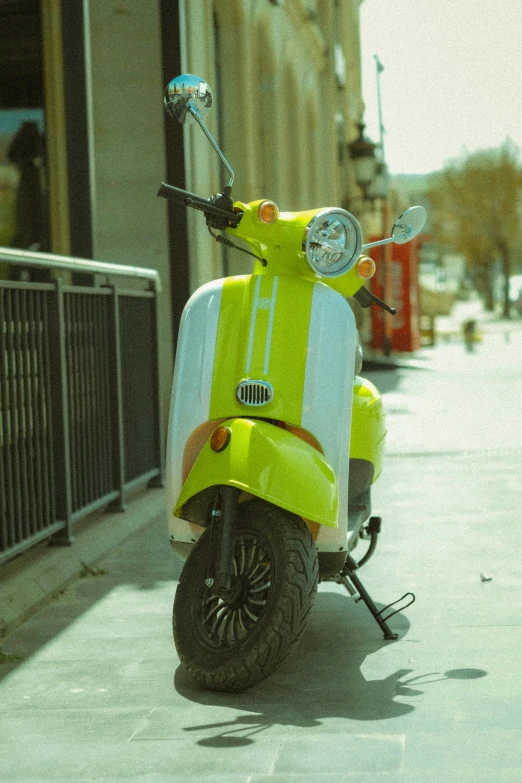 the side view of a scooter parked on the sidewalk