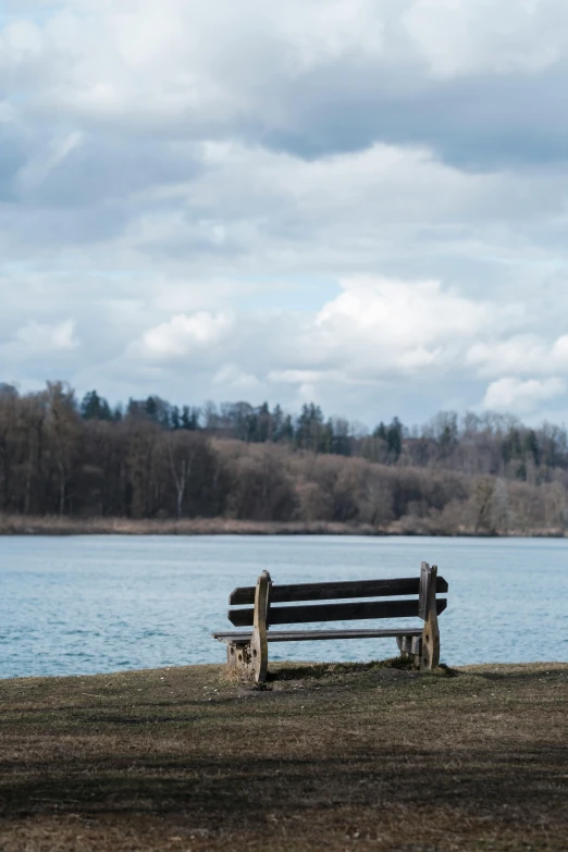 a bench on the edge of a lake next to a shoreline