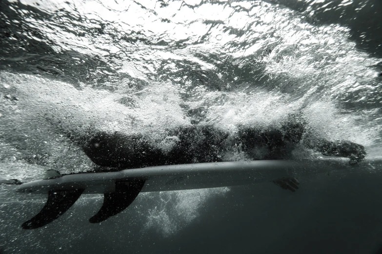 man laying on surfboard, coming into air above water