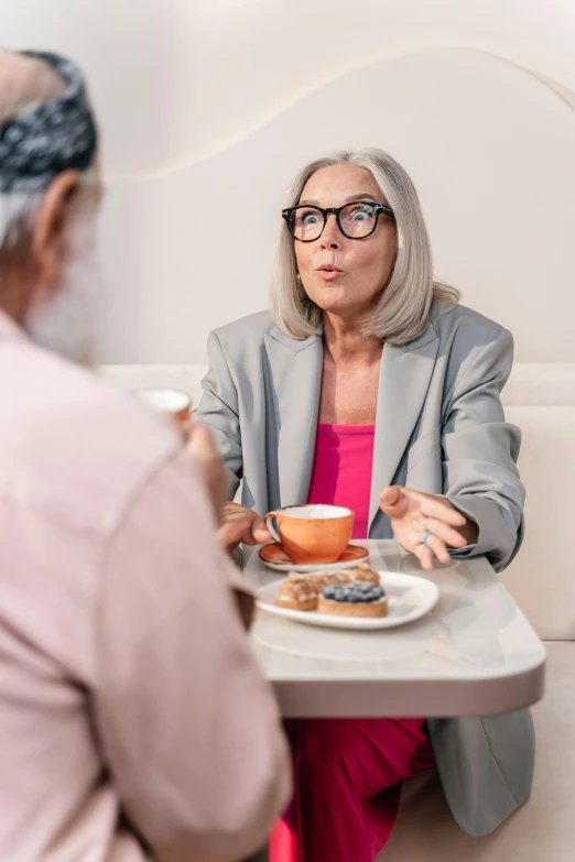 a woman sitting down to talk to another woman at a table