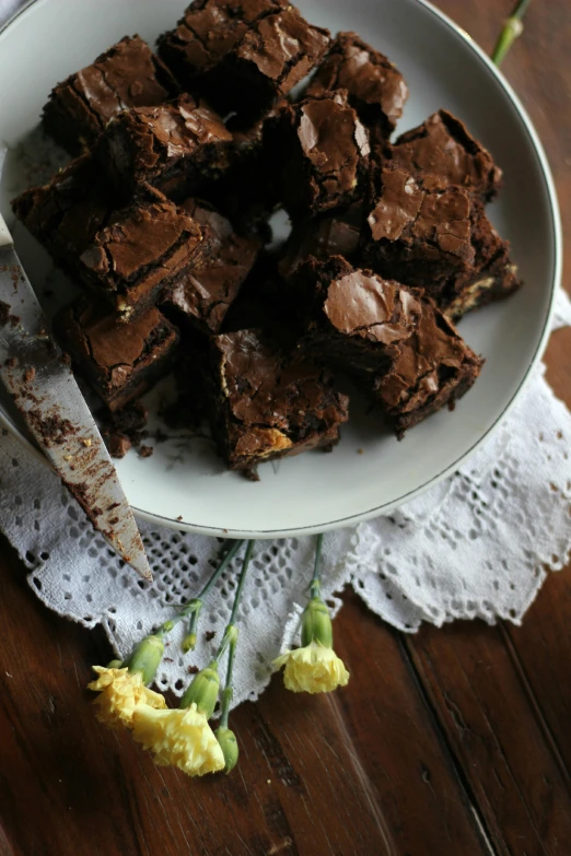 there is brownies on the plate with flowers on a table