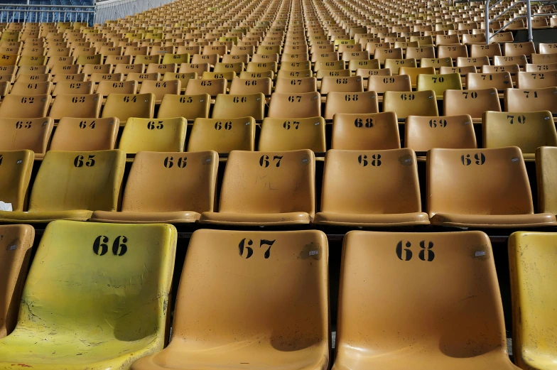 there is a row of yellow stadium chairs