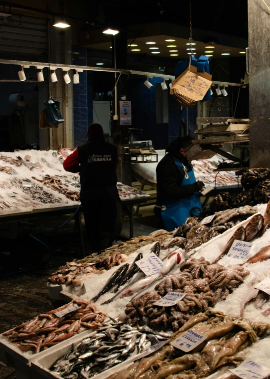 an outdoor market filled with fish and seafood