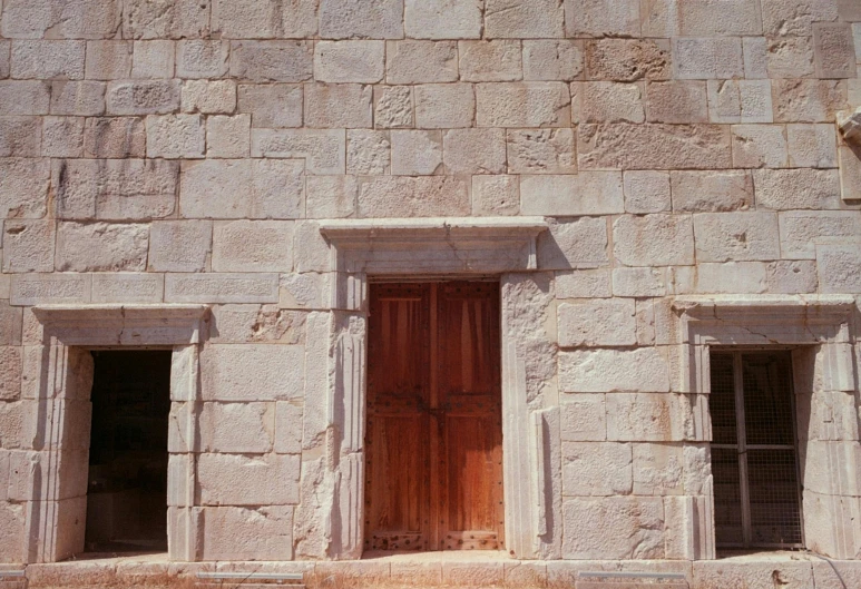 the brick walls are made of stone with two windows