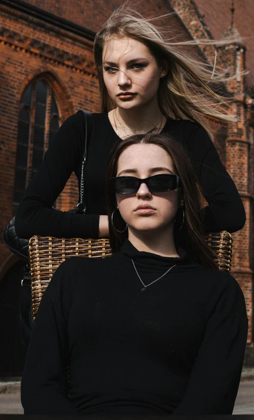 two women with black sunglasses posing for the camera