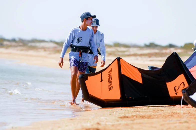 two men walking towards a parasol at the beach