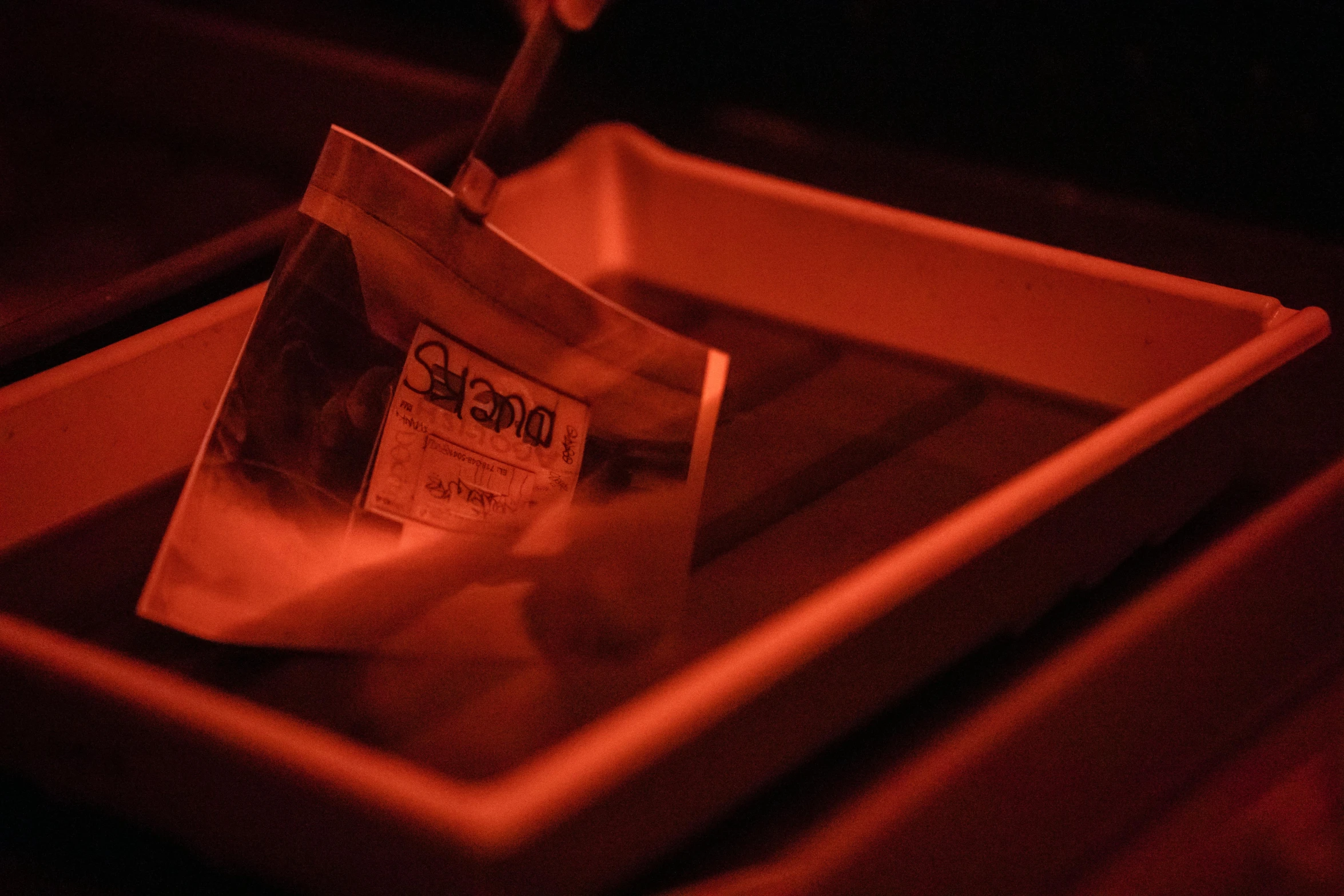 a red light po of papers laying in a bin