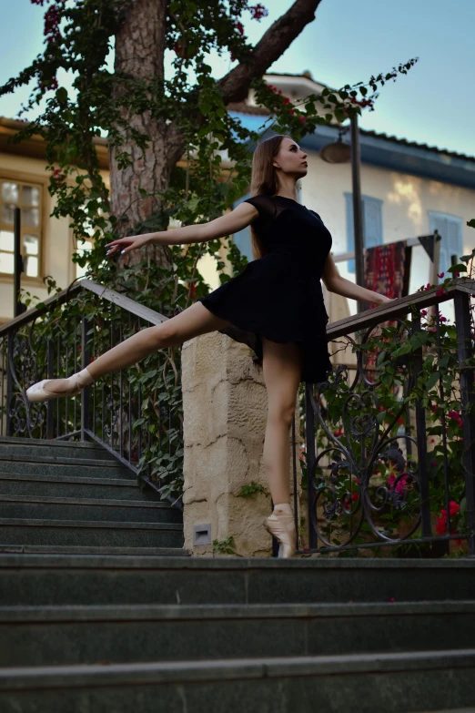 a beautiful young woman standing on a set of stairs