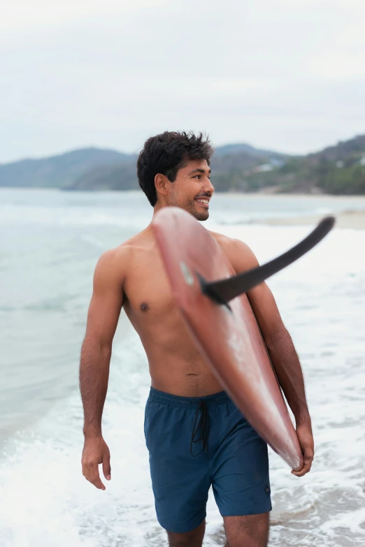 man with surf board walking in to the water