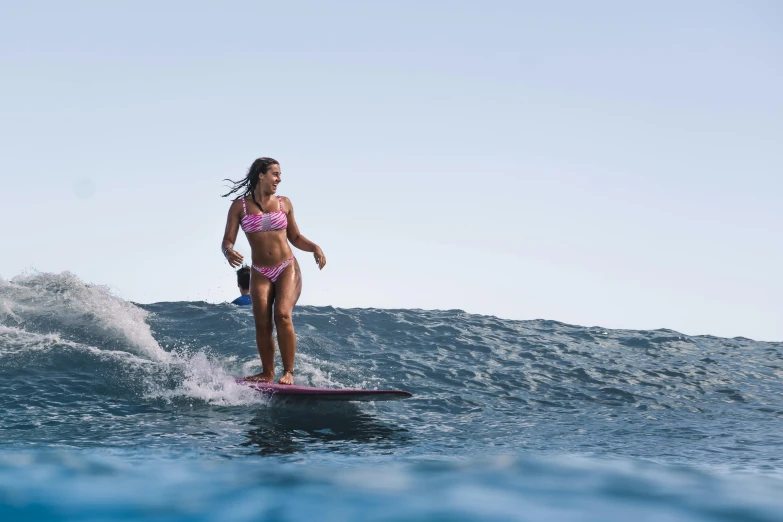 a woman riding a surfboard on top of a wave