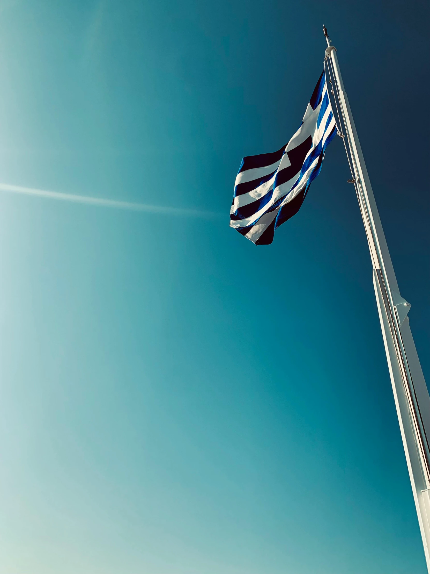 there is a large american flag flying over a blue sky