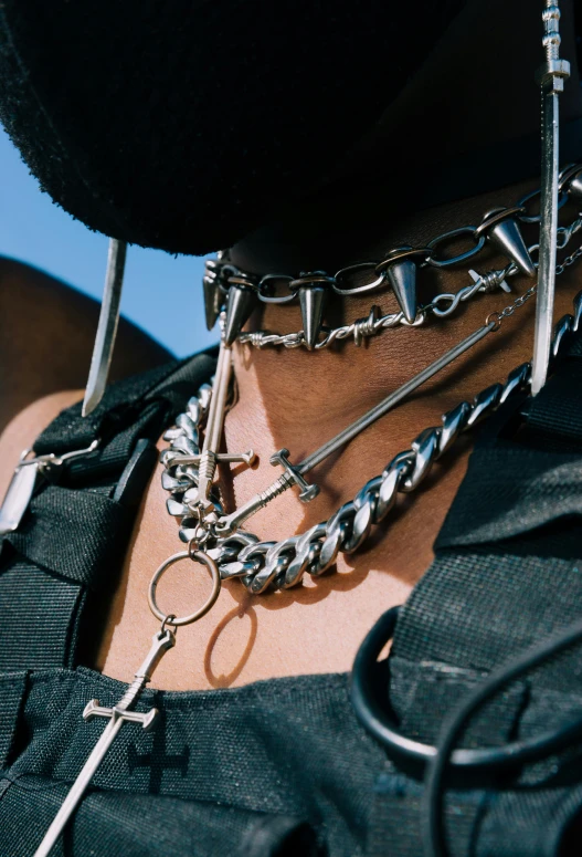 close up of several metal chains on a man's chest