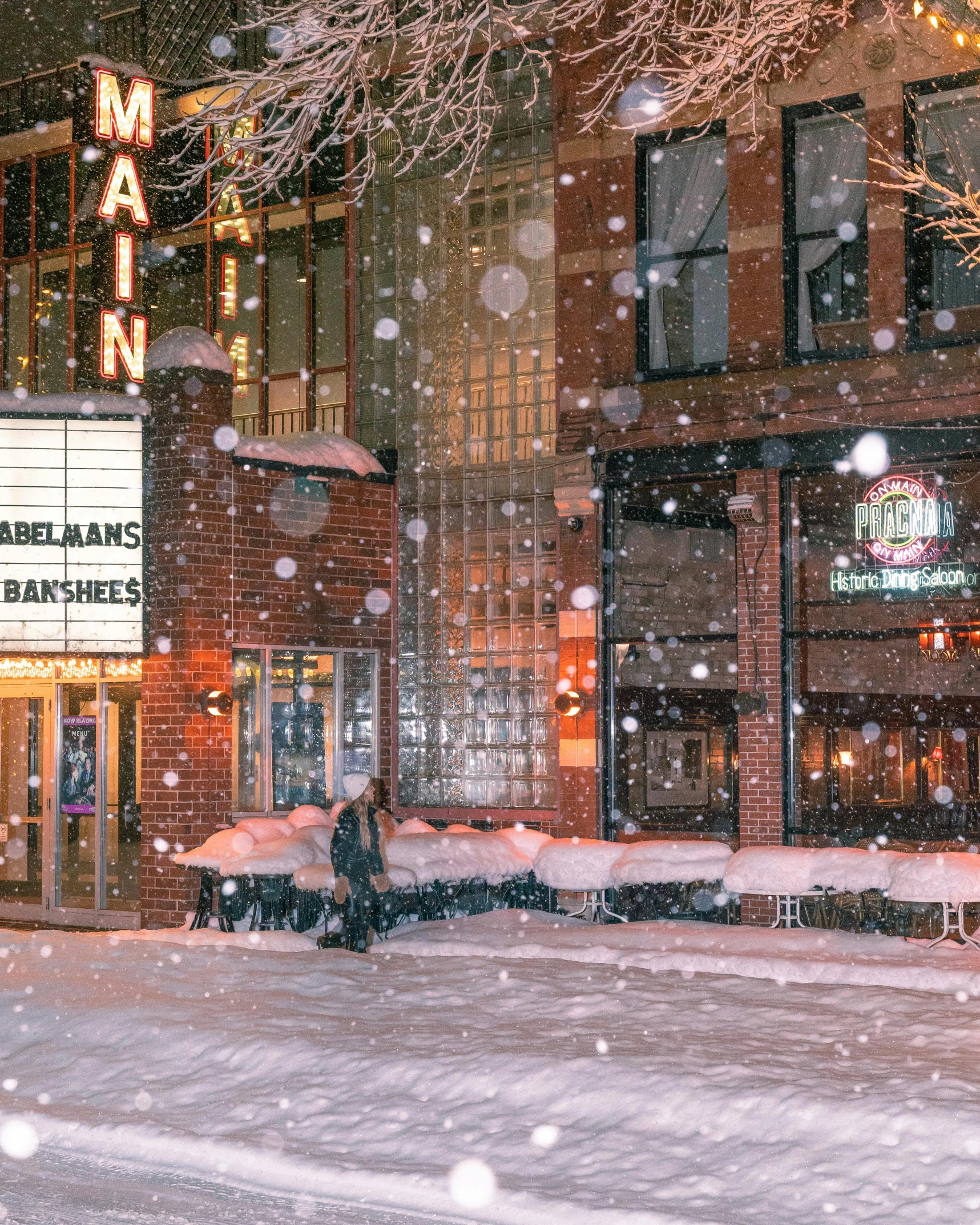 snow falling at night in front of a building