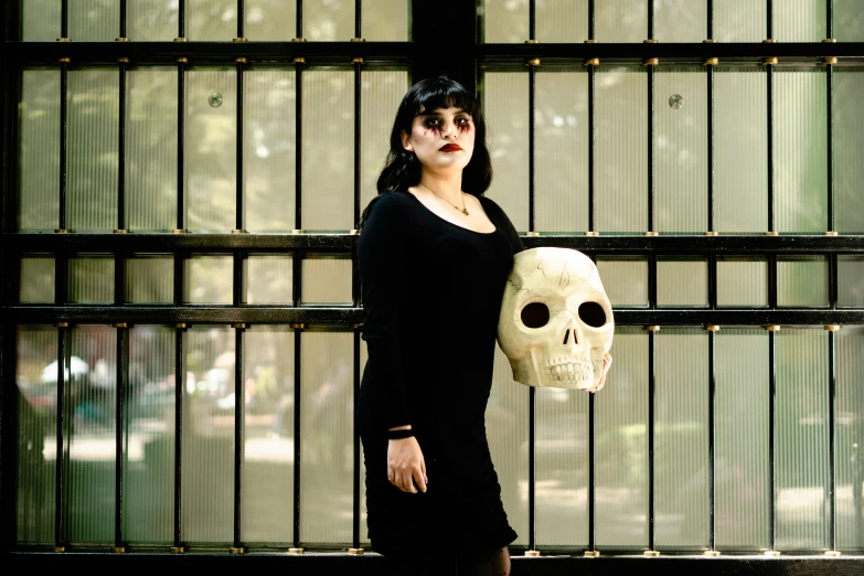 a woman in a dress holding up a large white skull