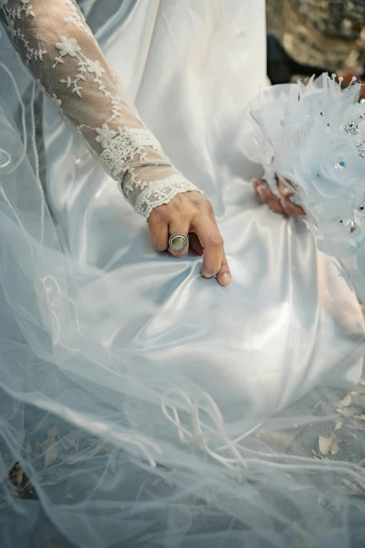 a person's hand with a ring on top of a dress