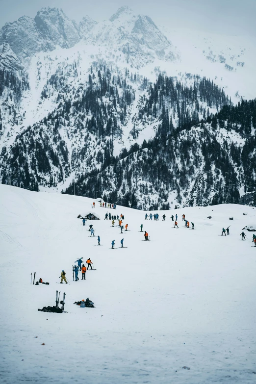 many people skiing on snow covered mountains