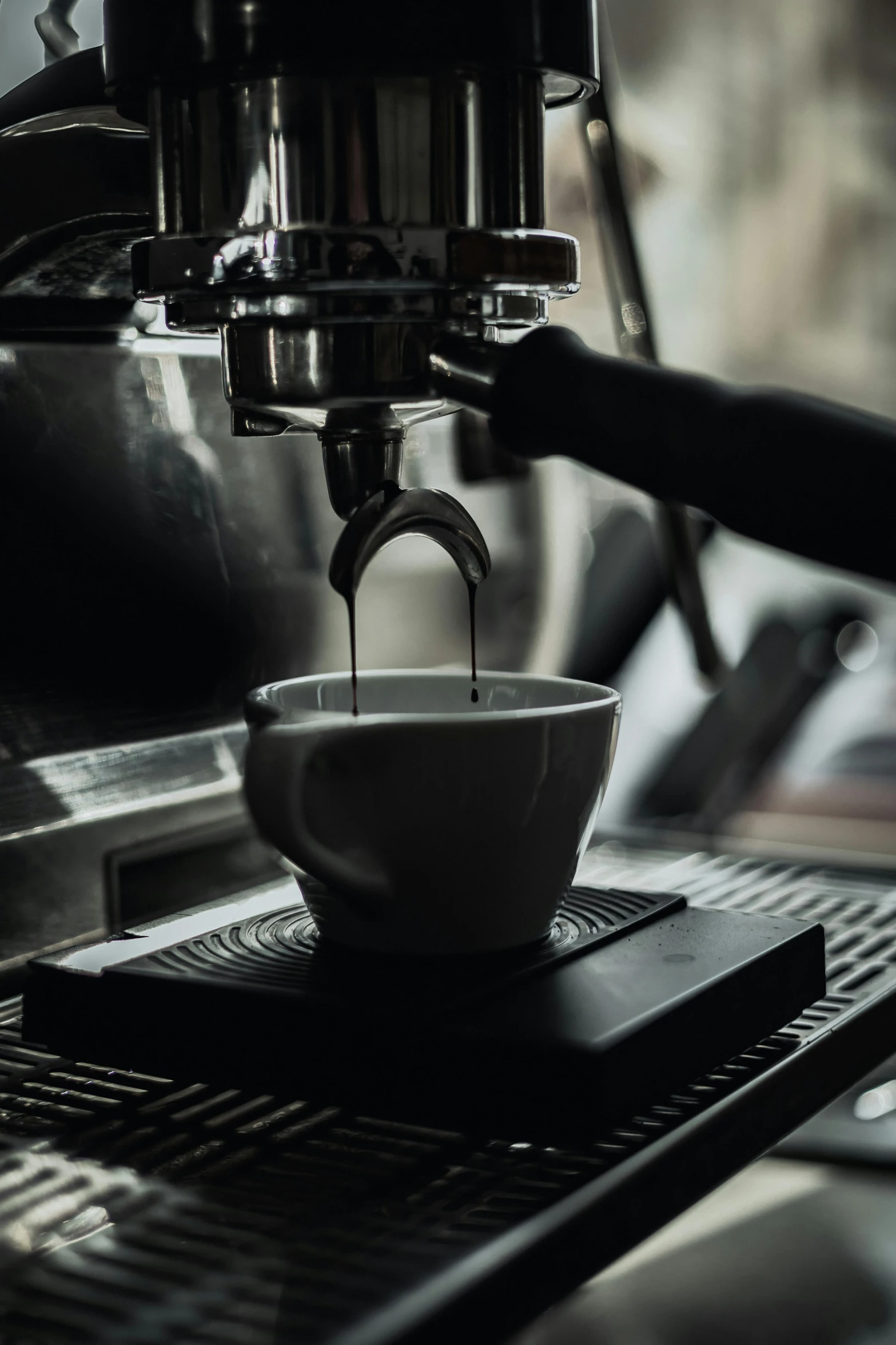 a coffee maker pouring some liquid in to a cup