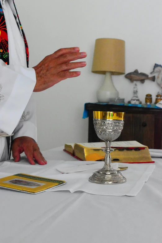 the priest is standing at his desk with his chalice