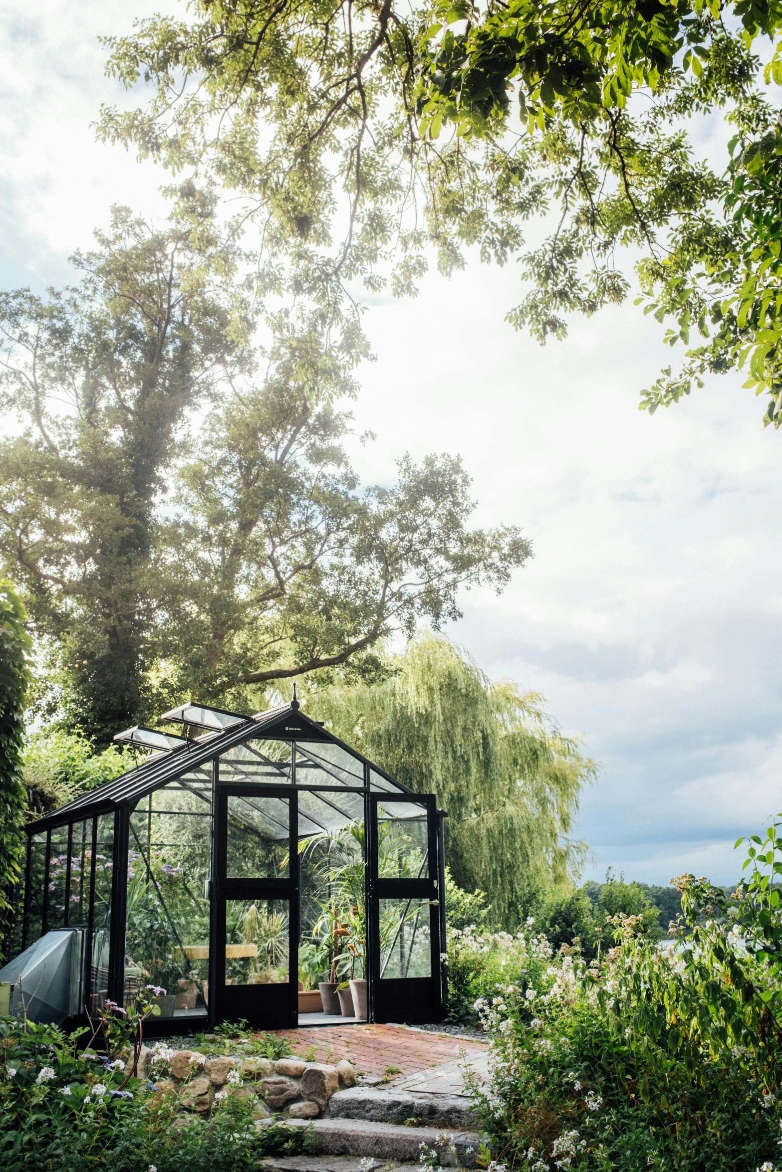 a green house in the middle of some shrubbery