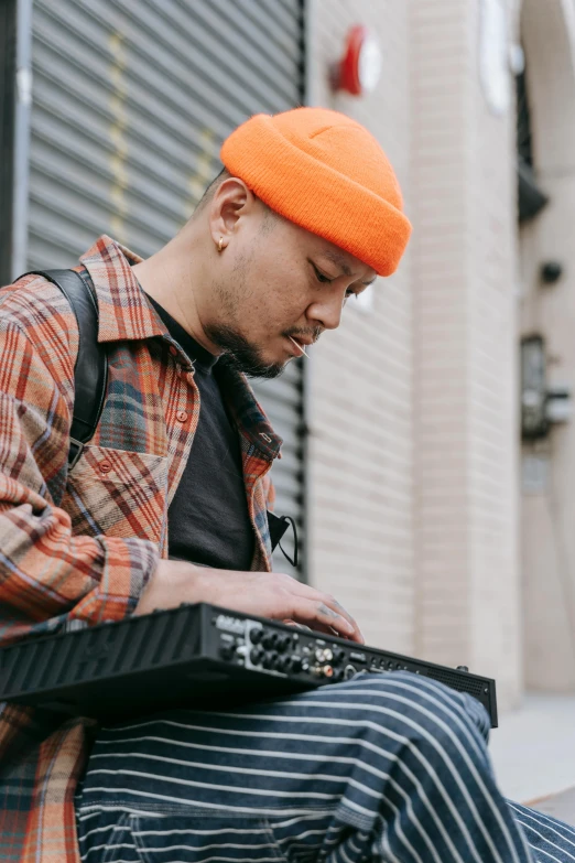 a man sitting on a bench wearing an orange hat