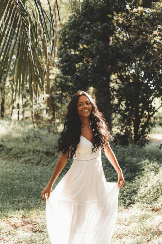 a woman in a long dress walking in a field