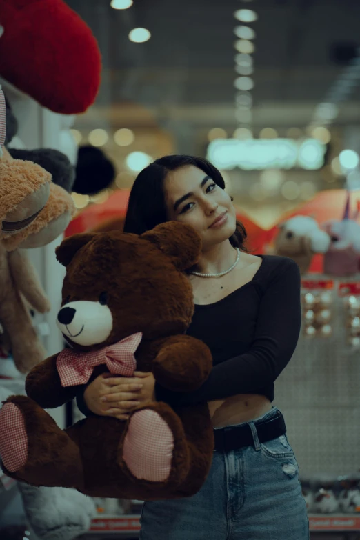 young woman in a shopping mall holding teddy bears