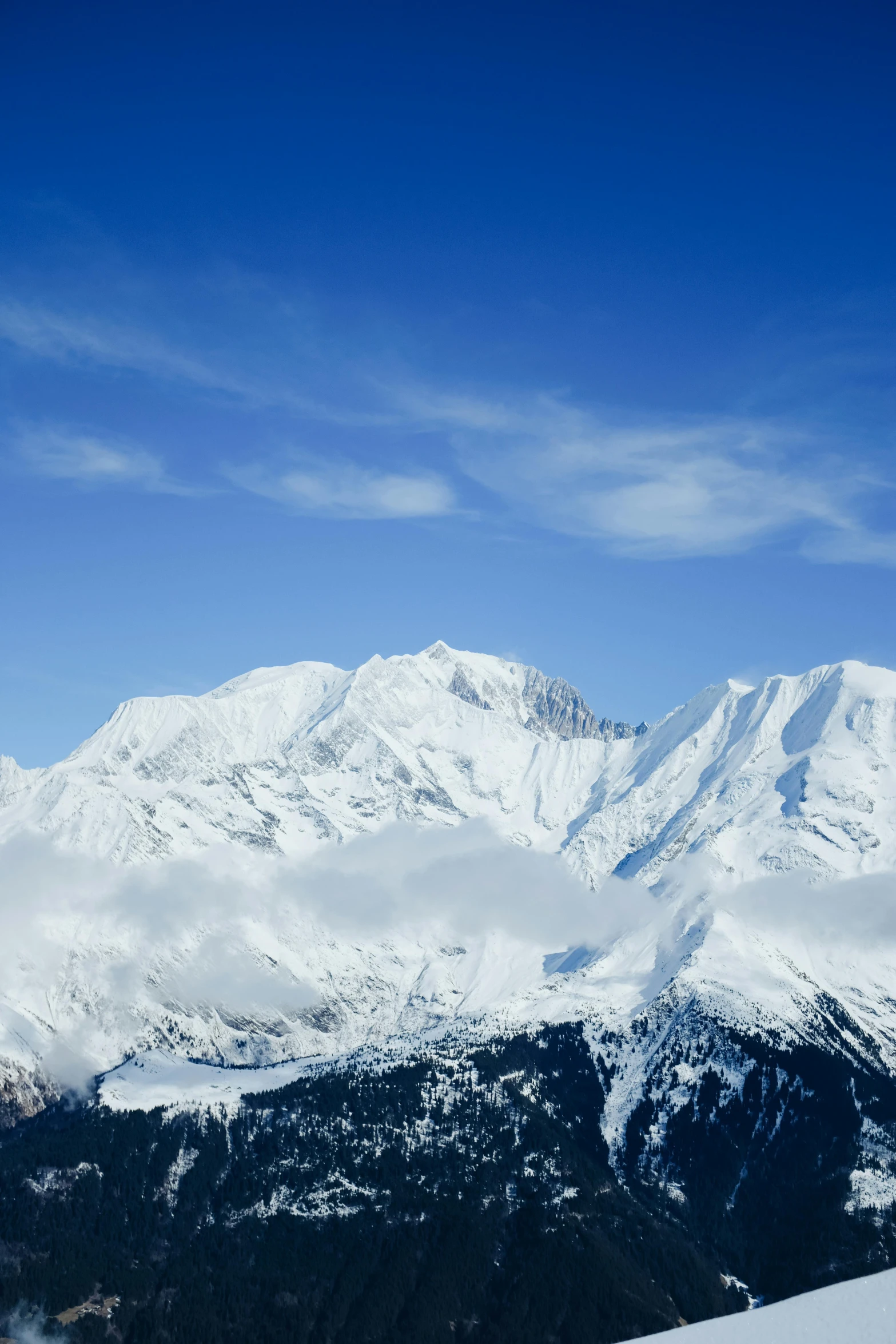 a very snowy mountain range covered in clouds