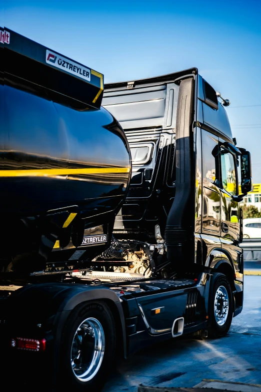 a large black truck parked next to an older car