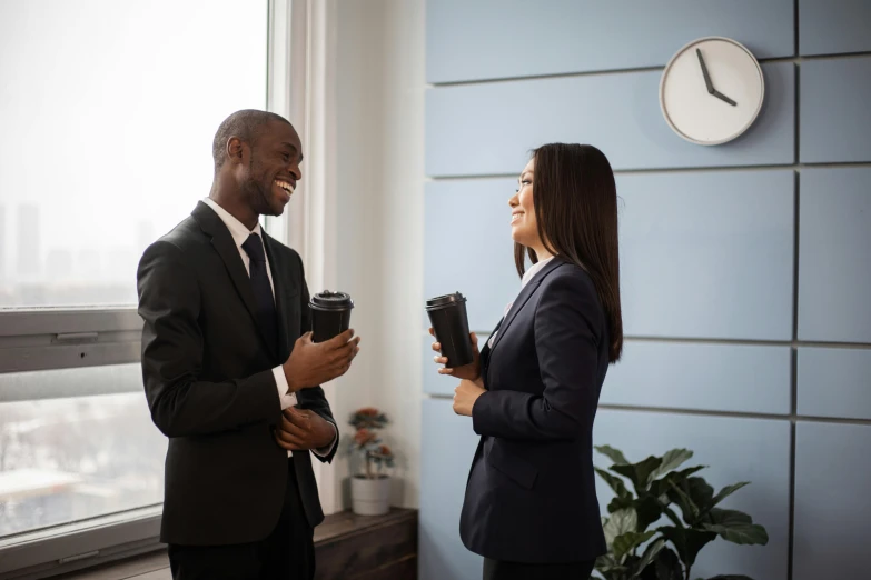 there is a man and woman in suits standing together talking to each other