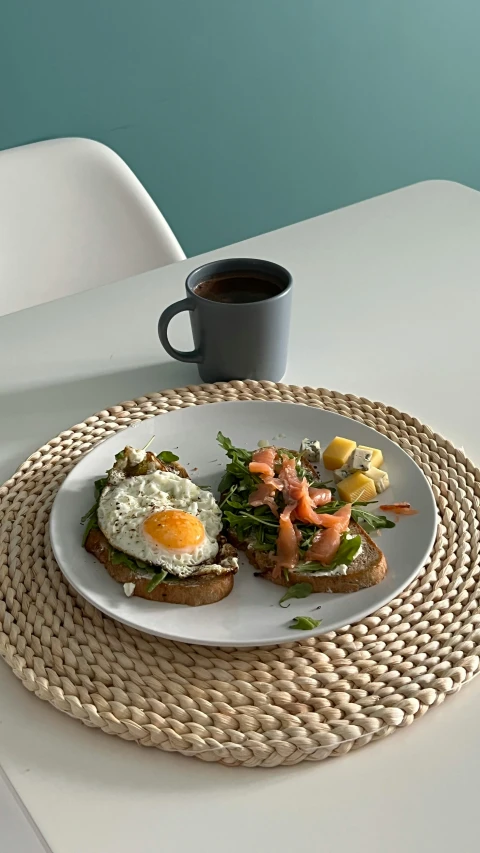 some eggs and vegetables are on a plate near a cup