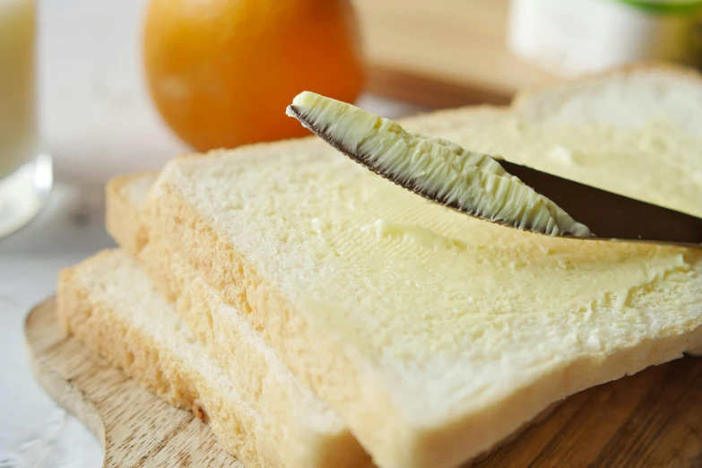 a knife sticking out the side of a piece of bread