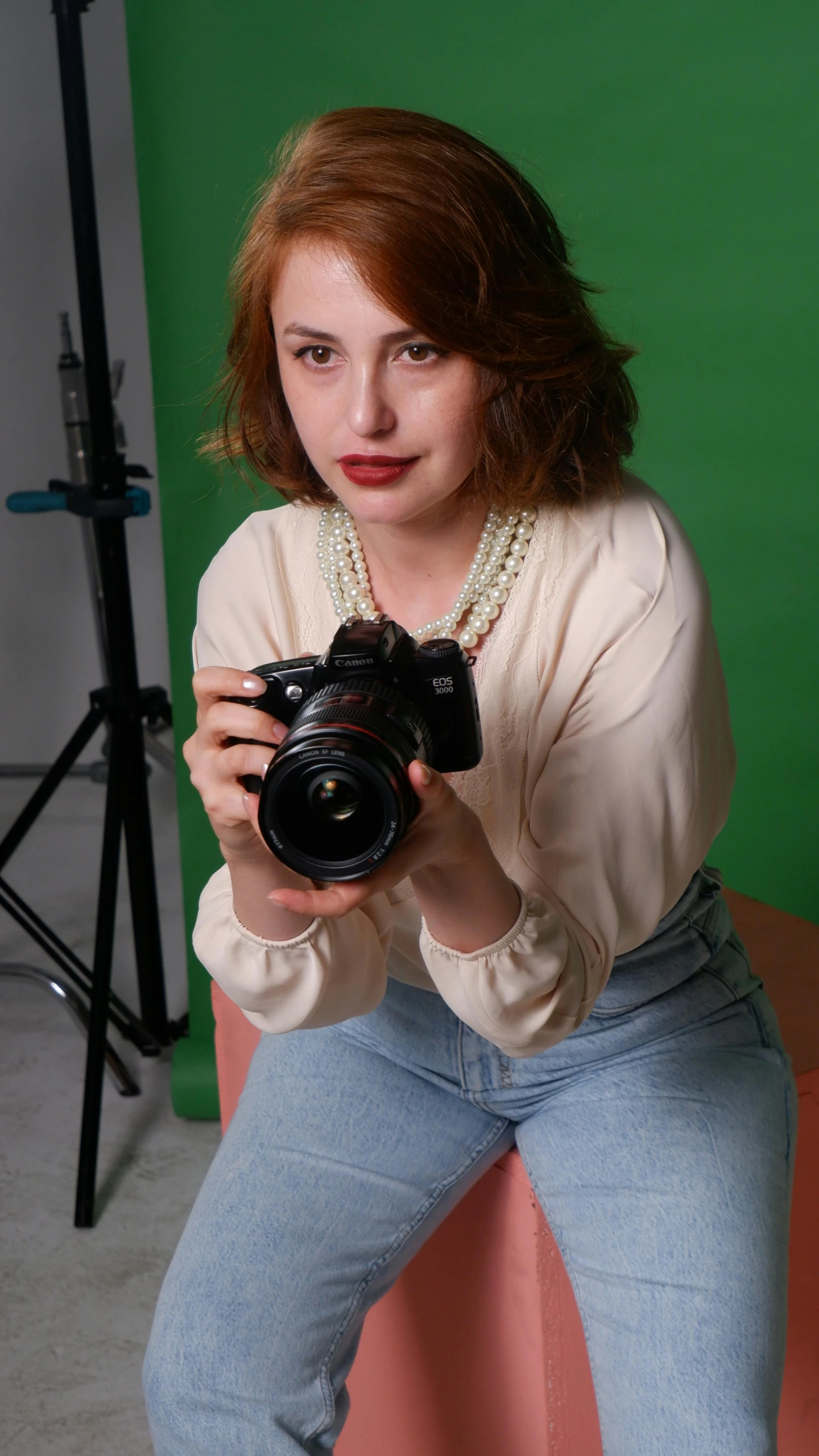 a girl holding up a camera and posing for the camera