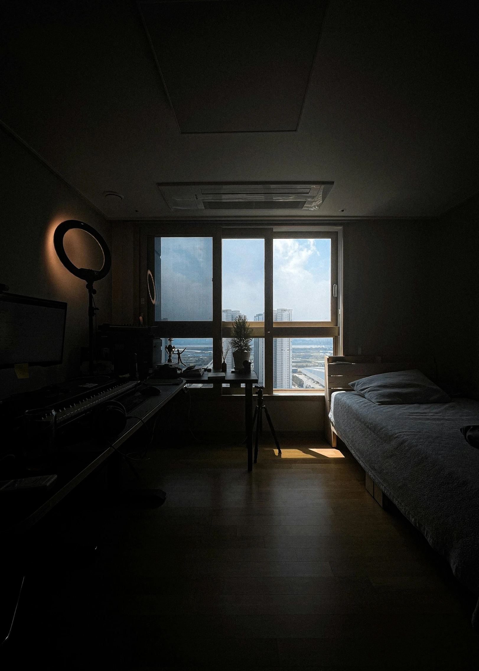 a dimly lit bedroom with a big window