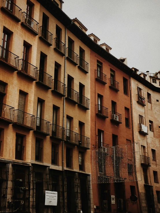 a tall brown building sitting next to a couple of small buildings