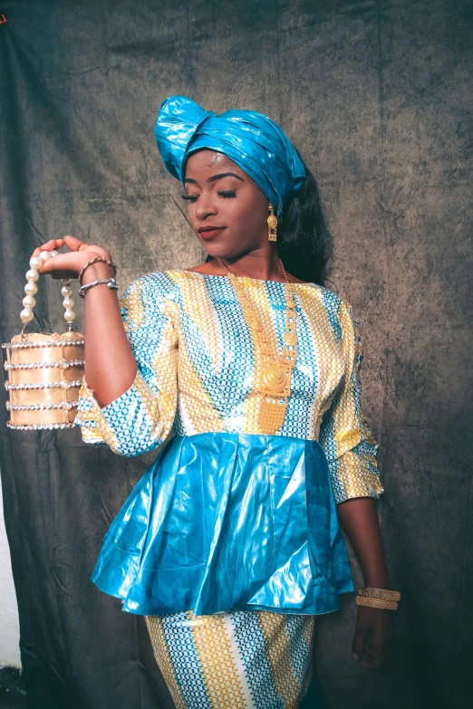 the woman is wearing a blue and yellow african - inspired dress