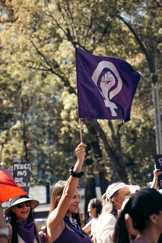 some women are marching down the street holding flags