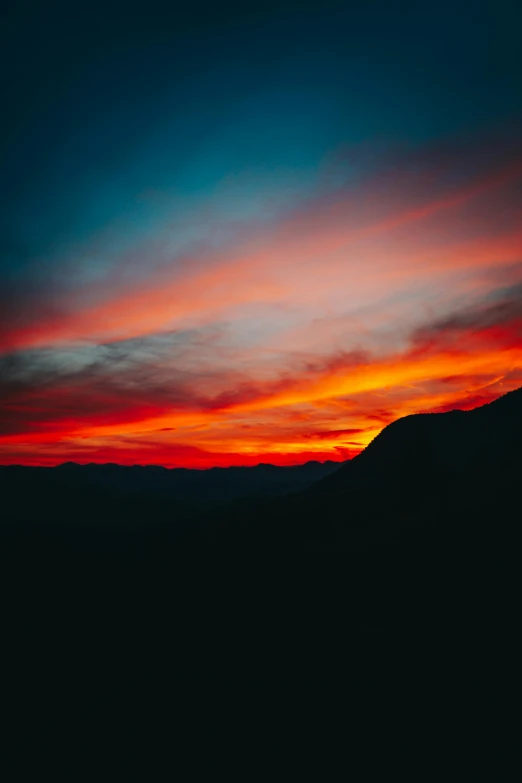 a dark image of the sky and mountains, with only clouds in view