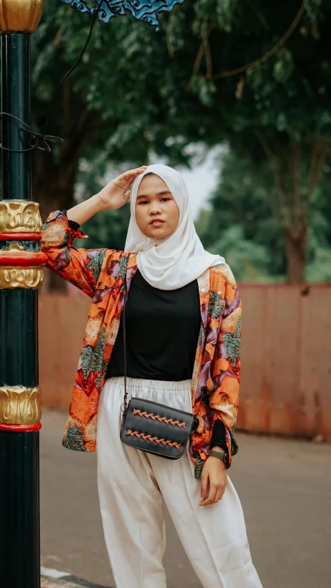 a woman leaning on a lamp post and posing for the camera