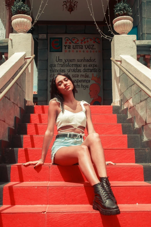 a woman sitting on red steps in front of a building