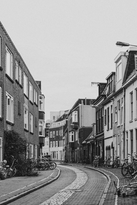 a black and white image of a road with some buildings