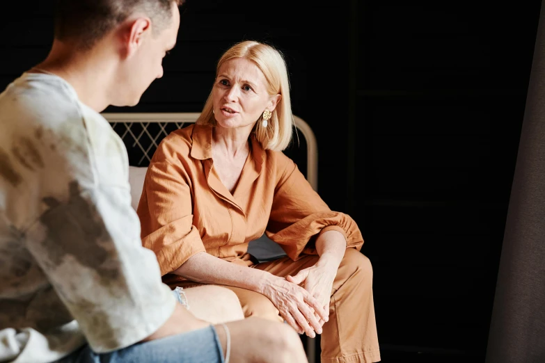 a man sitting next to a woman who is talking