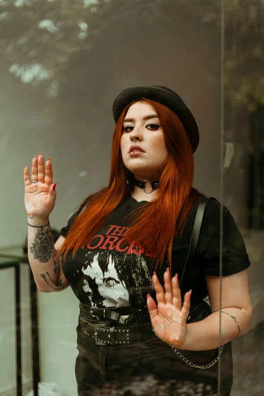 woman with red hair posing with her hands in air