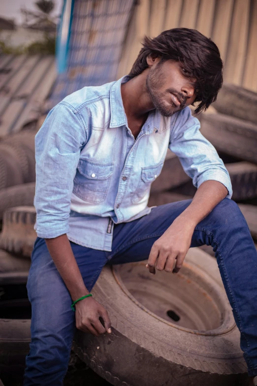 a man leaning on some tires on the road