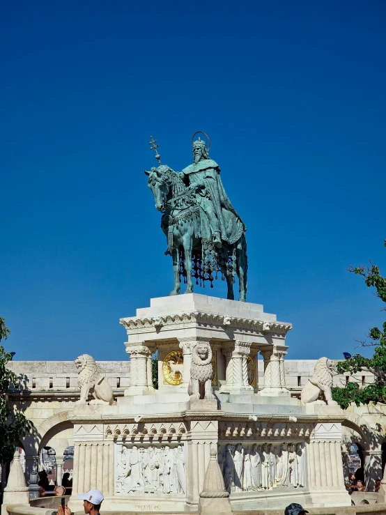 the people are by the statue of a man on a horse