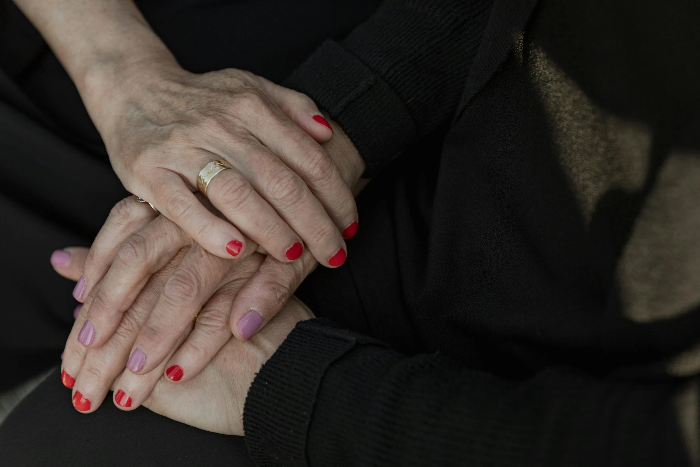 a woman sitting down holding another person's hands